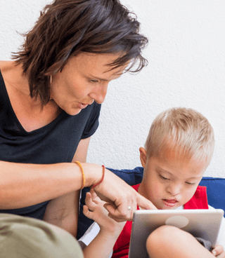 The boy with yellow shirt is examining the Otsimo app.