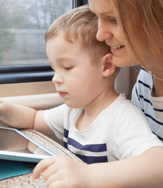 The kid is playing with Otsimo app on tablet with her teacher.