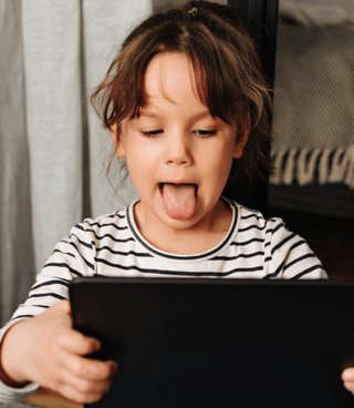 The boy is playing with Otsimo app on tablet with her teacher.